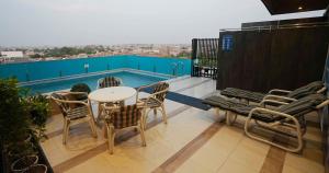 un balcon avec une table et des chaises et une piscine dans l'établissement Best Western Plus Grand Multan, à Multan