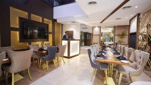 une salle à manger avec tables et chaises et une télévision dans l'établissement Best Western Plus Grand Multan, à Multan