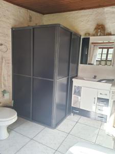 ein Badezimmer mit Toilette und einem großen grauen Schrank in der Unterkunft Sítio do Berger in São Gabriel