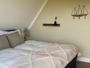 una camera da letto con un letto con un piumone bianco di Salzwiesenblick a Westerdeichstrich