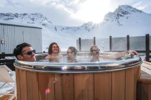 a group of people in a hot tub with a mountain at Belambra Clubs Tignes Val Claret in Tignes