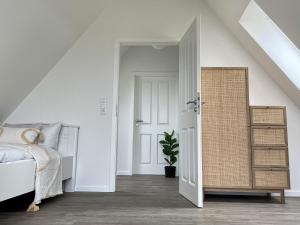 una camera da letto con un letto e una porta che conduce in una stanza di Salzwiesenblick a Westerdeichstrich Altre 13 foto