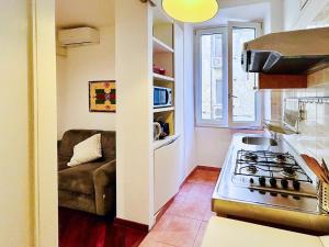 una cucina con fornello forno superiore accanto a un divano di Suite Vaticana 9 a Roma