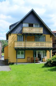 a yellow house with a deck and a porch at Haus der Berge in Braunlage