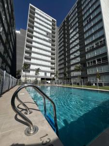 uma grande piscina com dois edifícios altos em 2 habitaciones 1 baño- a pasos de restaurantes centros comerciales em Rancagua
