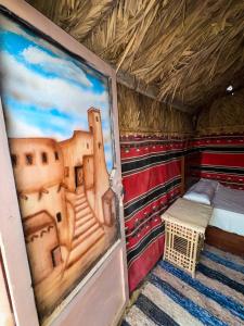 a room with a bed and a painting on the wall at El Dorado Camp in Siwa