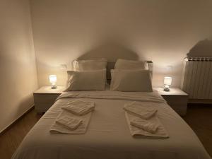 ein Schlafzimmer mit einem Bett mit zwei Handtüchern darauf in der Unterkunft Ulisse Fashion Suites - Ecosole Real Estate in Serravalle Scrivia