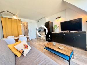 un salon avec un canapé et une télévision dans l'établissement COC - Le Panorama, à Wissant