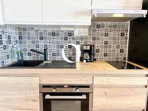 een keuken met een aanrecht met een fornuis en een wastafel bij COC - Le Panorama in Wissant