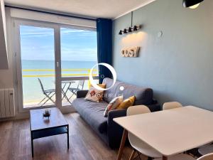 un salon avec un canapé et une vue sur l'océan dans l'établissement COC - Le Panorama, à Wissant