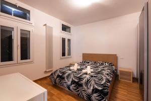 ein Schlafzimmer mit einem Bett mit einer schwarz-weißen Bettdecke in der Unterkunft Casa Naonis comfort and relax in the historic center in Pordenone
