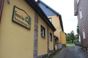 ein gelbes Gebäude mit einem Schild an der Seite in der Unterkunft Haus der Berge in Braunlage