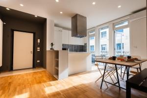 eine Küche und ein Wohnzimmer mit einem Tisch und einer Theke in der Unterkunft Casa Naonis comfort and relax in the historic center in Pordenone + 14 Fotos