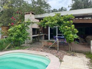 ein kleiner Pool vor einem Haus in der Unterkunft Hermosa, arbolada y espaciosa in La Floresta