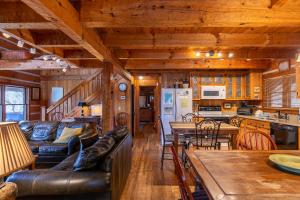 Una sala de estar con un sofá de cuero y una cocina. en Daniel Boone Lodge, en Boone