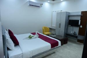 a hotel room with a bed and a tv at Hotel Akshay in Jaipur