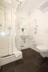 a bathroom with a shower and a sink and a toilet at Apartment Hotel am Sand in Hamburg