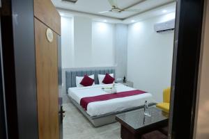 a bedroom with a large white bed with red pillows at Hotel Akshay in Jaipur