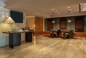 Sonesta Hotel Miraflores في ليما: لوبي مع طاولة وكراسي وغرفة طعام