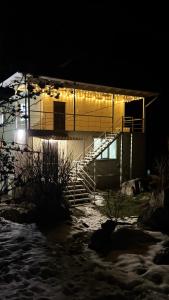 a building with lights on the side of it at night at Asman House in Alamedin