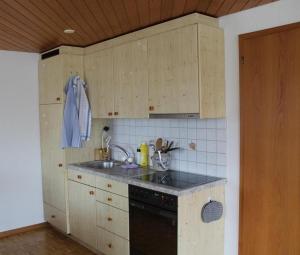 Una cocina con gabinetes de madera y un fregadero. en Steinern, en Ufhusen