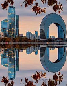 une vue de la silhouette d'une ville avec une sculpture dans l'eau dans l'établissement Baku Hotels, à Baku