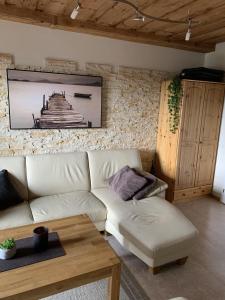 ein Wohnzimmer mit einer weißen Couch und einem Tisch in der Unterkunft Ferienwohnung für 4 Personen ca 50 m in Hauzenberg-Raßreuth, Bayern Bayerischer Wald in Hauzenberg + 31 Fotos