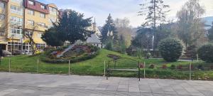 un parque con un banco frente a un jardín en Ali app, en Travnik