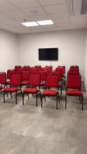 een conferentieruimte met rode stoelen en een scherm bij Hotel Vila Cop in Belém