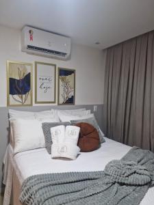 a bedroom with a bed with white sheets and pillows at Bauten Cabo branco -Flat moderno e confortável 314 in João Pessoa +26 photos