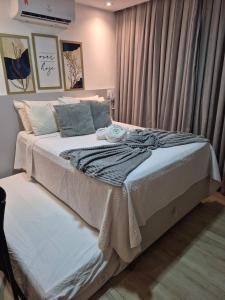 a bedroom with a large white bed with a window at Bauten Cabo branco -Flat moderno e confortável 314 in João Pessoa