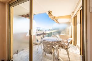a patio with a table and chairs on a balcony at meublé tourisme 3 étoiles vue mer in Golfe-Juan