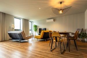 a living room with a dining table and chairs at Extra Large 2BR Apartment Next to Metro Station in Bicas