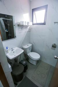 ein weißes Badezimmer mit Toilette und Waschbecken in der Unterkunft Mommy Irenes Place in Antipolo + 17 Fotos