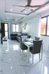 ein Wohnzimmer mit einem weißen Tisch und Stühlen in der Unterkunft Mommy Irenes Place in Antipolo