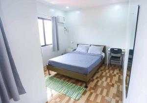 ein Schlafzimmer mit einem Bett, einem Fenster und einem Stuhl in der Unterkunft Mommy Irenes Place in Antipolo