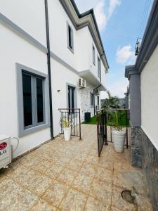 un patio con macetas junto a un edificio blanco en The bloom apartment, en Mama 1 foto más