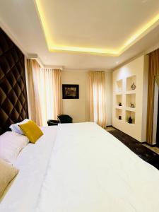 Un dormitorio con una gran cama blanca en una habitación. en The bloom apartment, en Mama