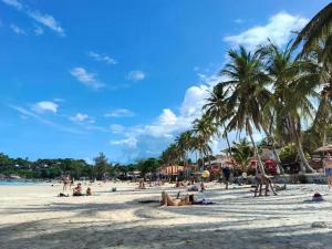 a group of people on a beach with palm trees at JAM's HOSTEL in Koh Phangan