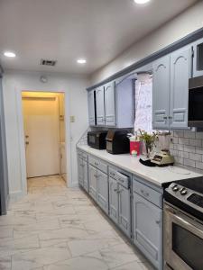 a large kitchen with white cabinets and a tile floor at Loue house in edmond, oklahoma by UCO in Edmond +11 photos