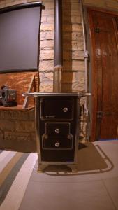 einen Holzofen in einem Zimmer mit einem TV in der Unterkunft L'esperienza - Chalés completos - Ecoturismo in Nova Petrópolis