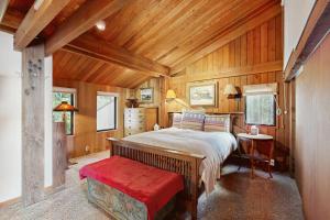 ein Schlafzimmer mit einem großen Bett und einer roten Bank in der Unterkunft Schooner in Sea Ranch