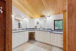 ein Badezimmer mit weißen Schränken und einer Holzdecke in der Unterkunft Schooner in Sea Ranch + 17 Fotos