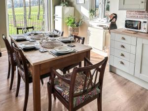 eine Küche mit einem Holztisch mit Stühlen und einem Esszimmer in der Unterkunft Talltrees - Uk42842 in Uplowman