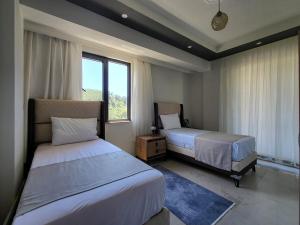 a hotel room with two beds and a window at Villa Hakan 1 - Luxury duplex villa in Dalaman