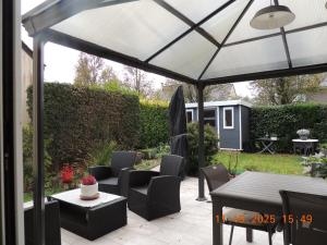 a white canopy over a patio with chairs and a table at Les Coquelicots Chambre d' hote avec grand lit et salle d'eau privative pour une persone ou un couple in Vern-sur-Seiche +3 photos