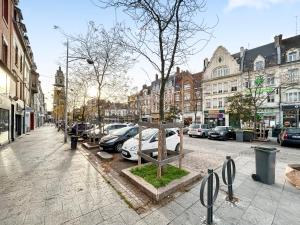 a city street with cars parked in a parking lot at Loft cosy, Canapé-lit & Mezzanine, cœur de Cambrai in Cambrai