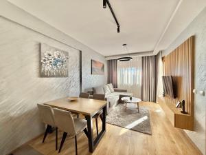 uma sala de estar com uma mesa e um sofá em Zlatibor Prestige Apartman 18 em Zlatibor