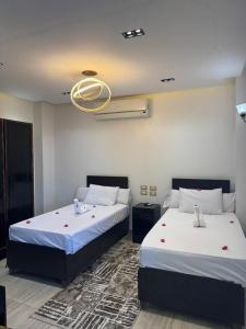 Un dormitorio con dos camas y una lámpara de araña. en Summer Land Hotel, en Abu Simbel 80 fotos más