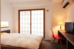 a bedroom with a bed and a desk and a television at Aizu-Wakamatsu "Yukkura Inn" self-service INN in Aizuwakamatsu +18 photos